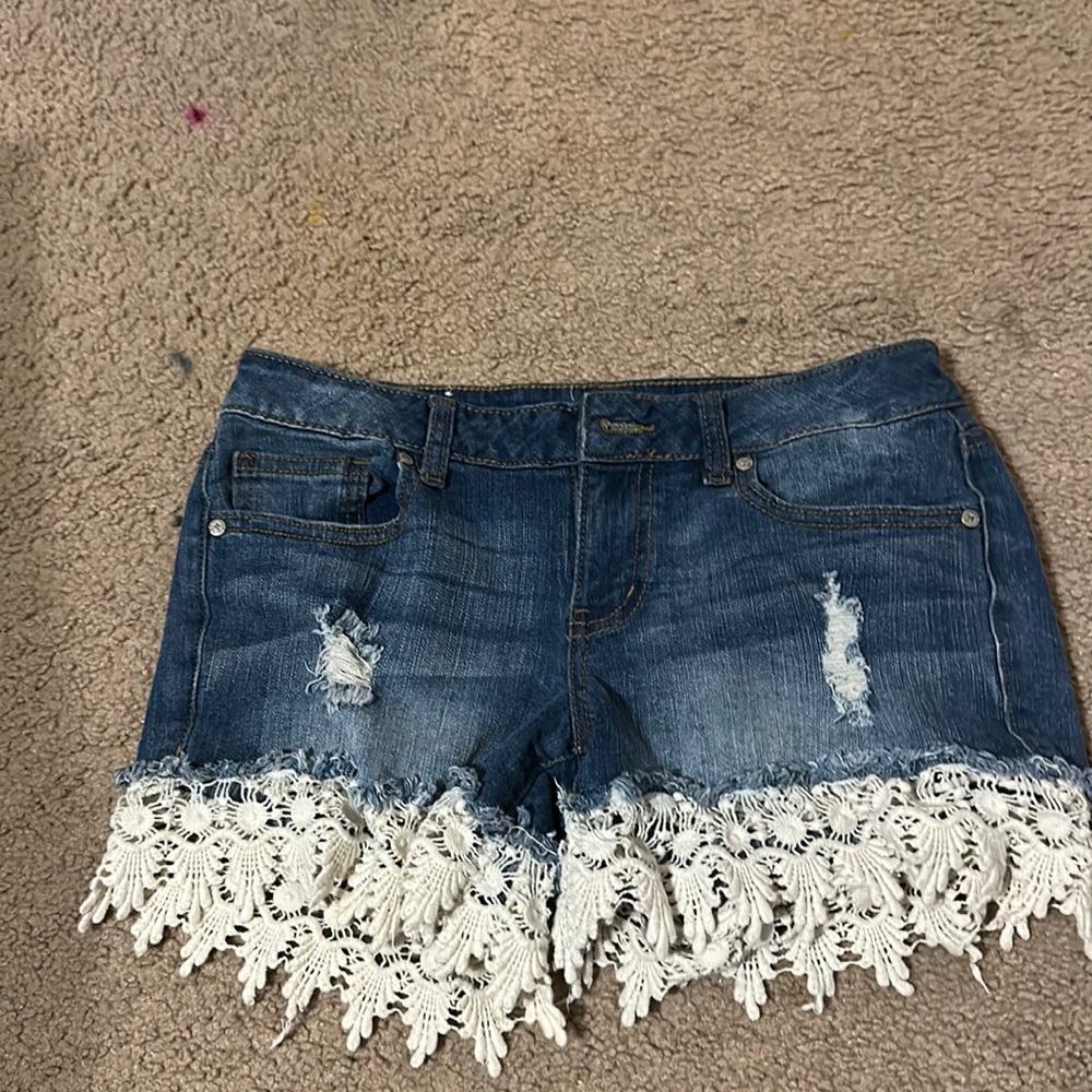 Size 26 in women’s. Blue Jean shorts with white lace.